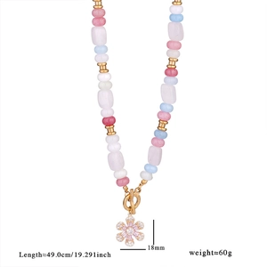 Detail of colorful stone beaded necklace with a pink zircon flower charm and golden OT clasp