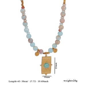Détail du collier de perles avec pendentif soleil doré et pierre turquoise