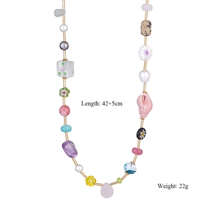 Dettaglio della collana di perline colorate con fiori e ciondolo carpa rossa