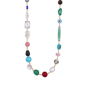 Dettaglio della collana di perline colorate con ciondoli a fiore e perle sintetiche