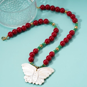 Beaded necklace with red beads, green spacers, and a large white shell butterfly pendant
