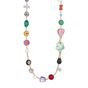 Close-up of bohemian beaded necklace with colorful stones, pearls and sea-style charms