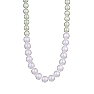 Detail of gradient pearl necklace featuring polished white and light green round pearls