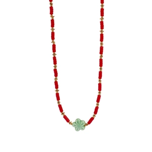 Detail of red column beads and gold spacers with a light green flower pendant necklace