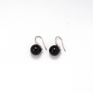 Detail shot of minimalist black bead earrings with silver hook on a white background