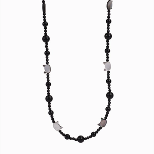 Detailed view of black onyx beaded necklace with white shell cat-shaped pendants