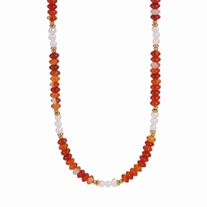 Macro view of red carnelian beads and freshwater pearls on a stainless steel necklace