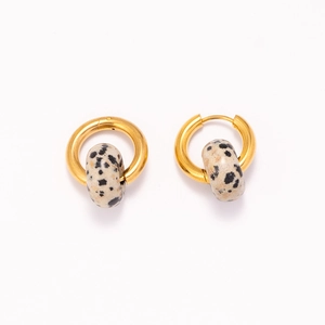 Detailed macro view of 18k gold hoops with unique black and white spotted stone beads
