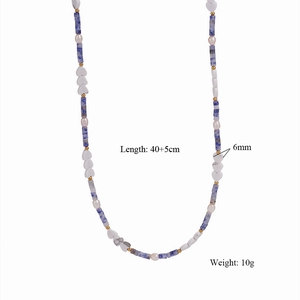 Dettaglio della collana fatta a mano con occhio di tigre, perle e un cuore marmorizzato