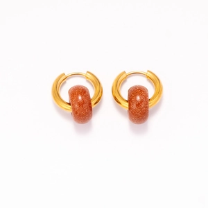Detailed macro view of 18k gold earrings featuring natural brown goldstone beads