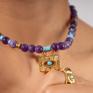 Bohemian beaded evil eye necklace with turquoise beads and gold pendant on female model