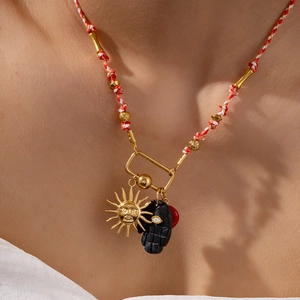 Colorful rope necklace with 18k gold plated sun and Hamsa hand charms on a female model