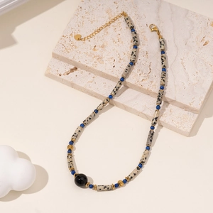 Minimalist beaded necklace with spotted stone, black agate, and gold heart charm detail