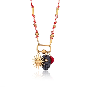 Detail of colorful cord necklace with gold sun, tribal mask, and red heart charms
