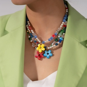 Detailed close-up of a three-layer colorful beaded necklace with striped flower pendants