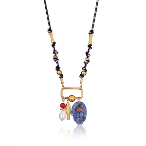 Detail of Hamsa hand pendant with blue stone and pearl on a colorful cord necklace