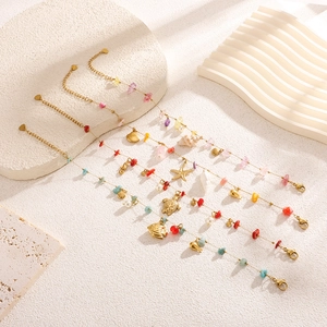 Detail of four gold-plated anklets with colorful natural stones and sea-themed charms