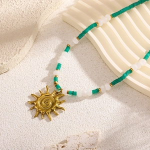 Bohemian gold sun pendant necklace with green and white beads for beach resort style