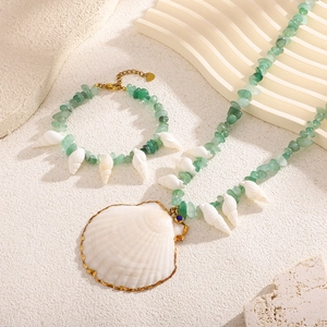 Detail of beaded necklace and bracelet with green aventurine stones and gold shells