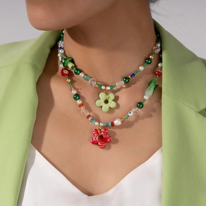 Colorful layered bead necklace with striped flower charms and green freshwater pearls