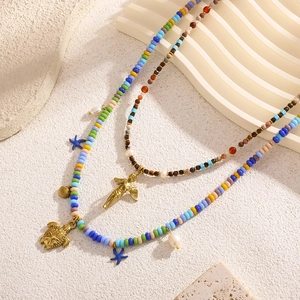 Bohemian layered beaded necklace featuring a golden turtle, shell, and angel pendant