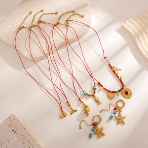 Parure de colliers minimalist cordon rouge avec breloques dorées océaniques et perles