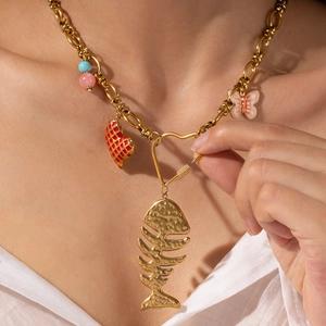 Dettaglio della collana a catena dorata con lisca, cuore e ciondoli colorati