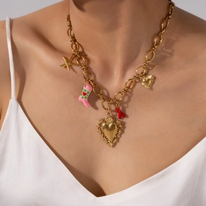 Goldene Edelstahlkette mit Herz, Seestern und pinkem Stiefel-Anhänger an weiblichem Model