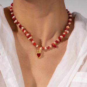 Colorful paperclip chain necklace with red stone beads and gold heart pendant worn on neck