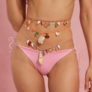 Détail de chaînes de taille bohèmes avec coquillages, étoiles de mer et perles colorées