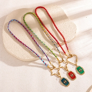 Détail macro de pendentifs mauvais œil tressés avec cristaux et cordons colorés