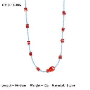 Detail of beaded necklace with light blue stones and a red polka dot fish pendant