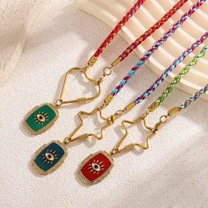 Détail de pendentifs œil porte-bonheur avec cordes tressées et fermoirs cœur dorés