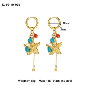 Détail de boucles d'oreilles étoile de mer avec perles turquoise et rouges en acier