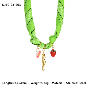 Detailed close-up of green silk scarf necklace with stainless steel sea charms
