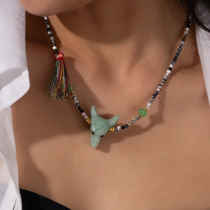 Dettaglio della collana con ciondolo volpe in pietra naturale verde e nappe di seta