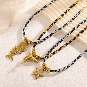 Ocean-themed necklaces with shark, dolphin, and starfish pendants on leopard cord