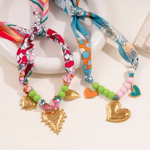 Detail of silk scarf necklace with gold heart charms and colorful acrylic beads