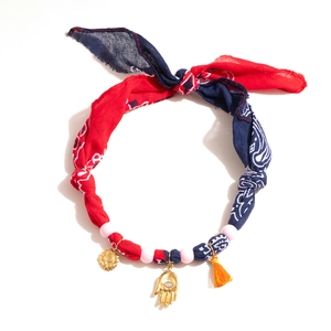 Detail of silk scarf necklace with Hamsa charm, sunflower pendant and orange tassels
