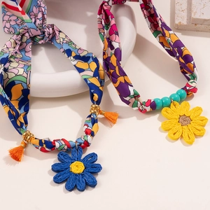 Detail of bohemian floral fabric necklaces with woven flower charms and colorful tassels