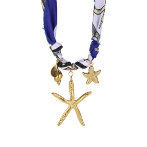Detail of nautical necklace showing gold conch and starfish charms on silk rope