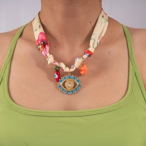 Dettaglio della collana foulard in seta con ciondoli a forma di croce e malocchio