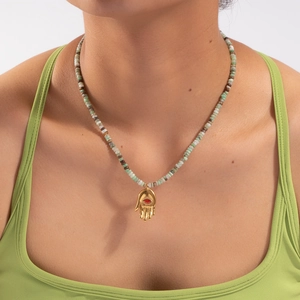 Détail du collier de perles colorées avec pendentif main de Fatma et pierre rouge