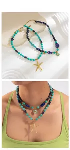 Close-up of ocean-themed layered necklace with turquoise beads and golden starfish charms