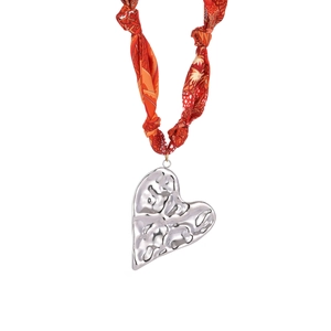 Dettaglio del ciondolo a cuore in argento strutturato con collana a foulard in seta arancione