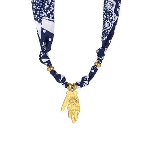 Dettaglio del ciondolo Mano di Fatima con motivi di sole e occhio su collana di stoffa