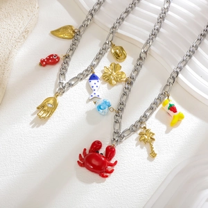 Détail du collier chaîne Figaro argentée avec breloques crabe et fraise colorées