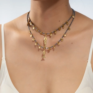 Detail of double-layer beaded necklace with gold fish pendants and grey stone beads