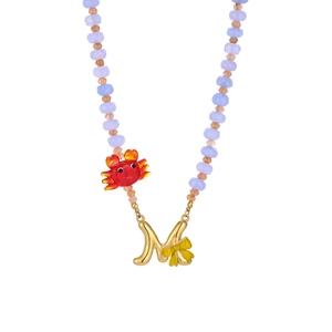 Macro detail of ocean-style beaded necklace with red crab and golden letter M pendant