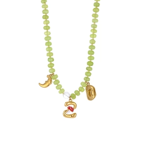 Macro detail of light green faceted beads and golden mushroom pendant on a necklace